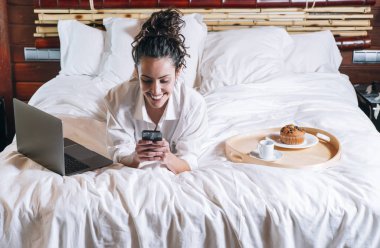 Telefonu ve laptop yatakta güzel kadın