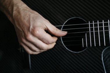 Karbon fiber gitar çalmak yaşlı adam