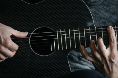 Karbon fiber gitar çalmak yaşlı adam