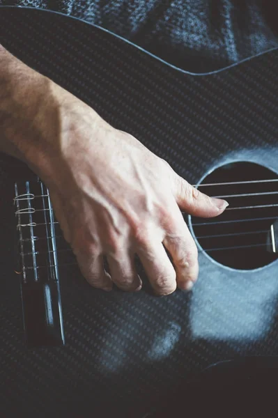 Homem idoso tocando guitarra de fibra de carbono — Fotografia de Stock