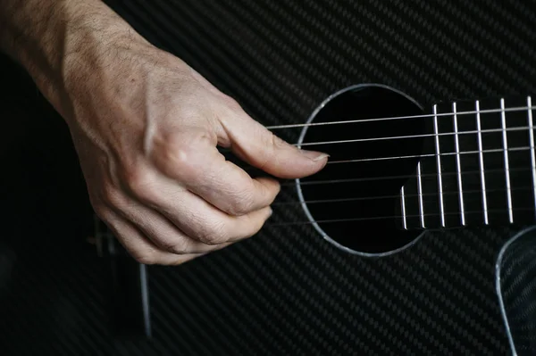 Homem idoso tocando guitarra de fibra de carbono — Fotografia de Stock