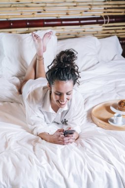 Güzel kadın yatakta telefon ile