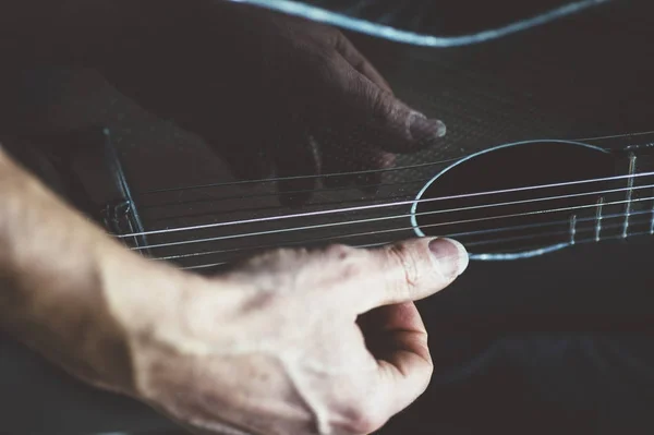 Homem idoso tocando guitarra de fibra de carbono — Fotografia de Stock