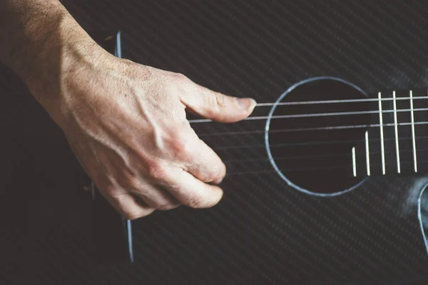 Starší muž hrát na kytaru uhlíkových vláken — Stock fotografie