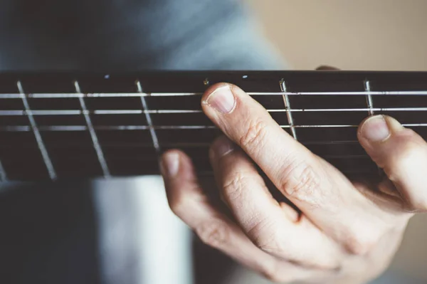 Starší muž hrát na kytaru uhlíkových vláken — Stock fotografie