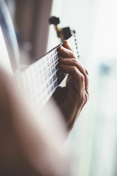 Літній чоловік грає на гітарі з вуглецевого волокна — стокове фото