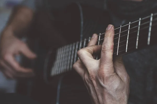 Пожилой человек играет на углеродной гитаре — стоковое фото