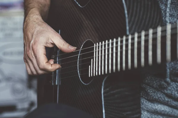 Homem idoso tocando guitarra de fibra de carbono — Fotografia de Stock