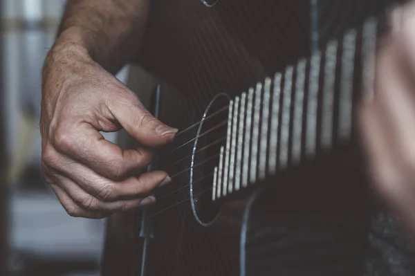 Homem idoso tocando guitarra de fibra de carbono — Fotografia de Stock