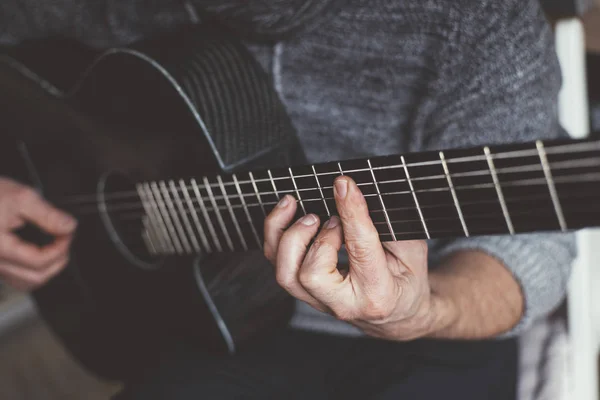 Elderly man playing carbon fiber guitar — Stock Photo, Image