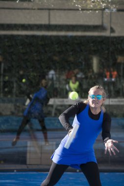 Bir kadın 47 yaşında raket tenis oynuyor