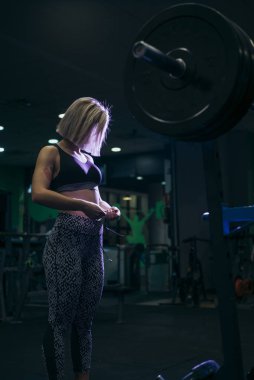 Spor salonunda ağırlık ile çalışan kadın