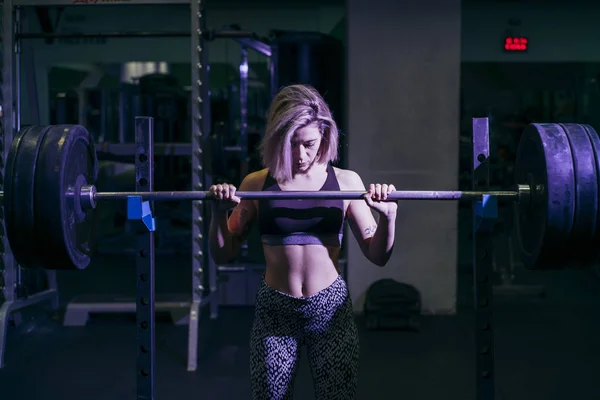 Mujer haciendo ejercicio con pesas en el gimnasio — Foto de Stock