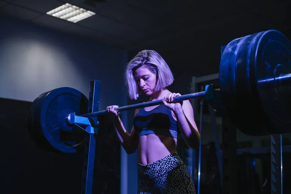 Mujer haciendo ejercicio con pesas en el gimnasio — Foto de Stock