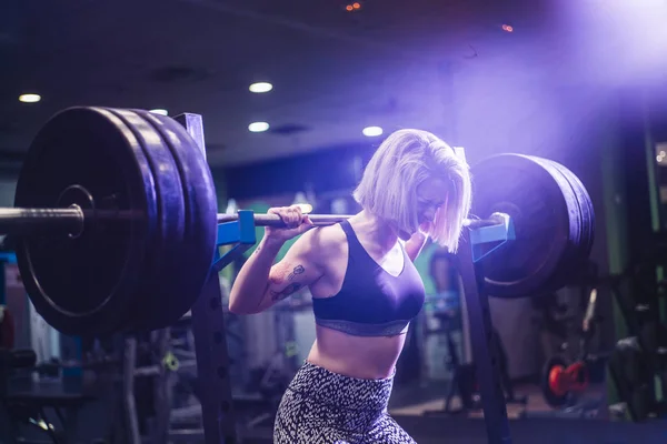 Mujer haciendo ejercicio con pesas en el gimnasio — Foto de Stock