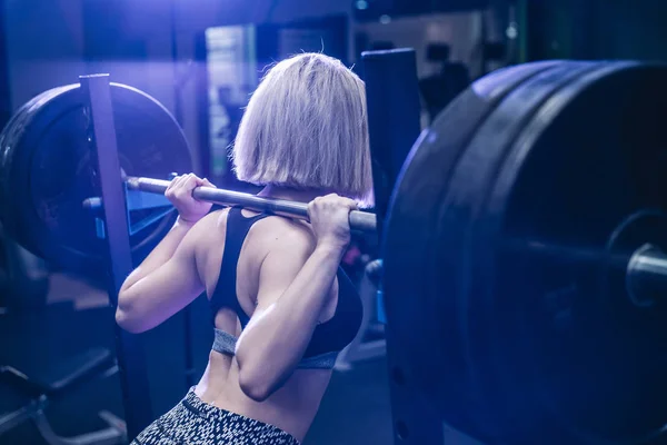 Mujer haciendo ejercicio con pesas en el gimnasio — Foto de Stock