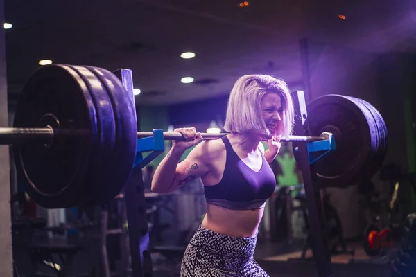 Mujer haciendo ejercicio con pesas en el gimnasio — Foto de Stock