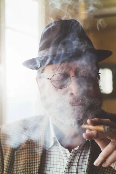 Senior man with a smoking cigarrete — Stock Photo, Image