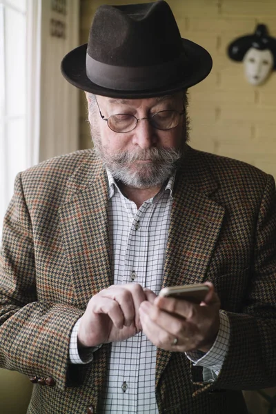 Мужчина 72 лет со смартфоном — стоковое фото