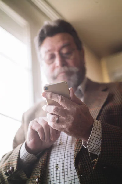 Мужчина 72 лет со смартфоном — стоковое фото