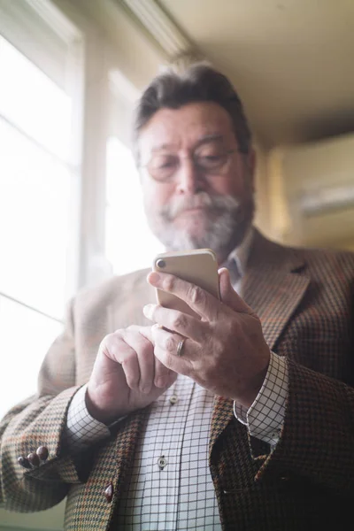Mannen i 72 år gammal med smartphone — Stockfoto