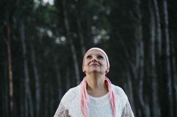 Kvinna med rosa huvudduk i skogen, har cancer — Stockfoto