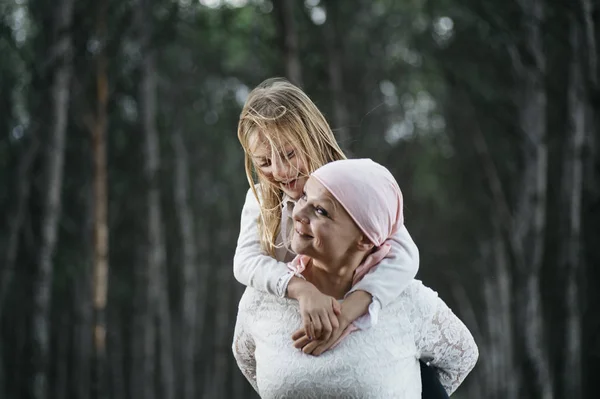 A woman with cancer is  next to her daughter. A girl is hugging — Stock Photo, Image