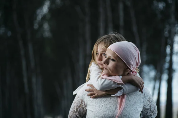 Uma mulher com cancro está ao lado da filha. Uma rapariga está a abraçar — Fotografia de Stock