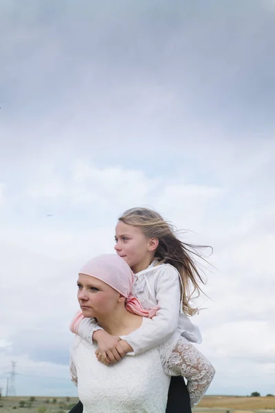 Una mujer con cáncer está al lado de su hija. Una chica se está abrazando —  Fotos de Stock