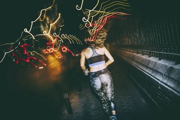 Жінка практикує біг у місті вночі Ліцензійні Стокові Фото