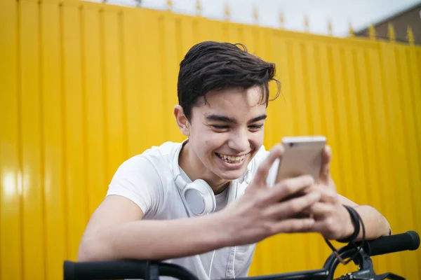 Πορτρέτο του όμορφος έφηβος χαμογελά όταν χρησιμοποιεί του mobil — Φωτογραφία Αρχείου