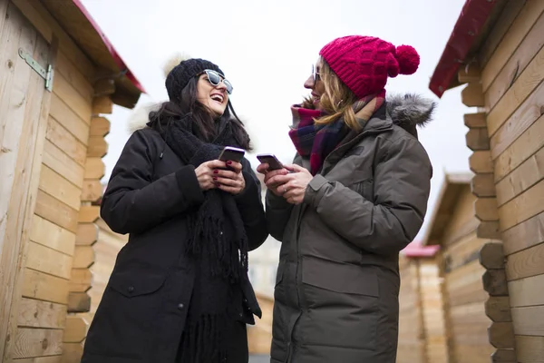 Duas amigas usando celulares . — Fotografia de Stock