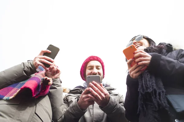 Grupul de prieteni care folosesc telefoane mobile . — Fotografie, imagine de stoc