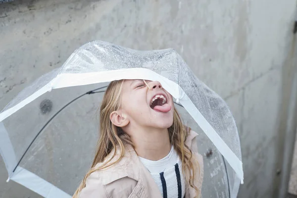 Dziewczynka z niebieskimi oczami i duże jasne parasol. — Zdjęcie stockowe