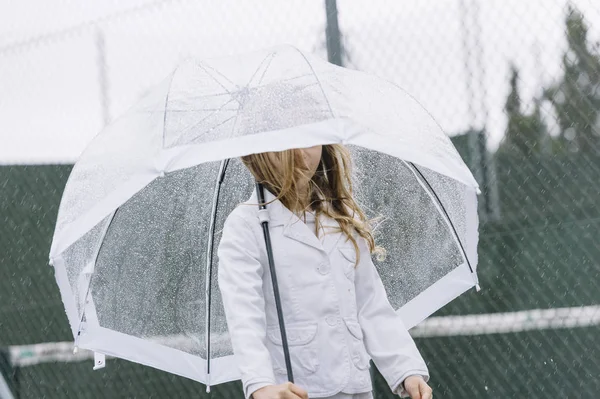 Little girl with blue eyes  and big clear umbrella. — Stock Photo, Image