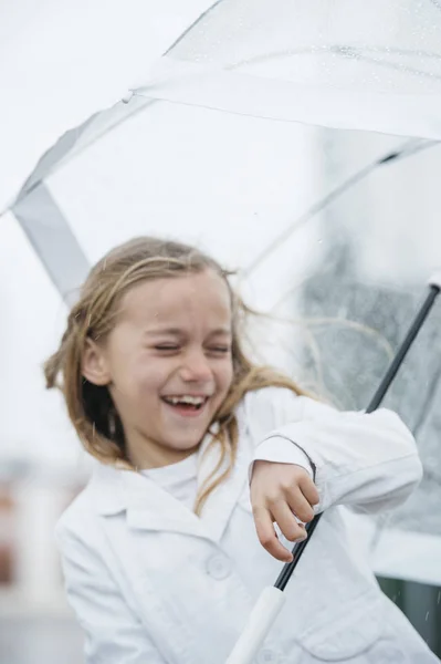 Little girl with blue eyes  and big clear umbrella. — Stock Photo, Image