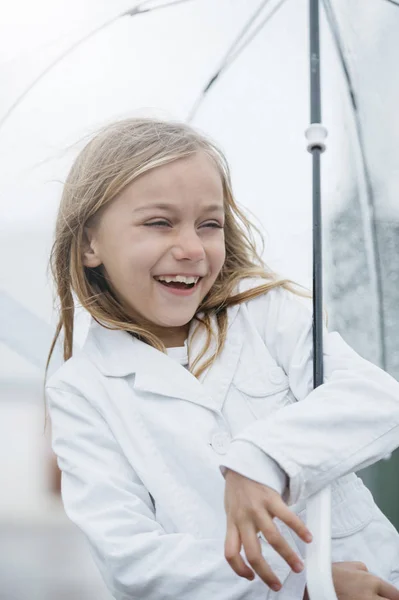 Dziewczynka z niebieskimi oczami i duże jasne parasol. — Zdjęcie stockowe