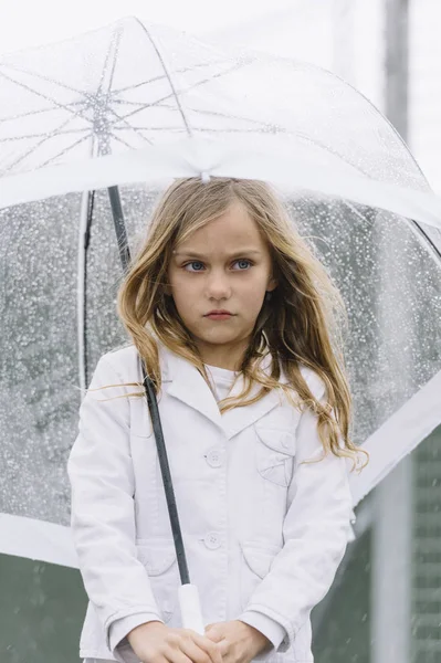 Dziewczynka z niebieskimi oczami i duże jasne parasol. — Zdjęcie stockowe