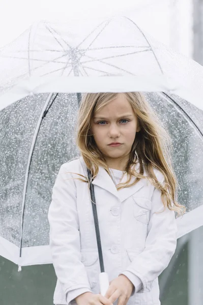 Little girl with blue eyes  and big clear umbrella. — Stock Photo, Image