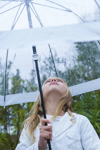 Little girl with blue eyes  and big clear umbrella. — Stock Photo, Image