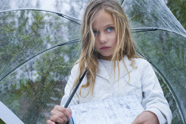 Маленька дівчинка з блакитними очима і великою чіткою парасолькою . — стокове фото