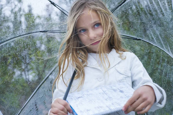 Маленька дівчинка з блакитними очима і великою чіткою парасолькою . — стокове фото