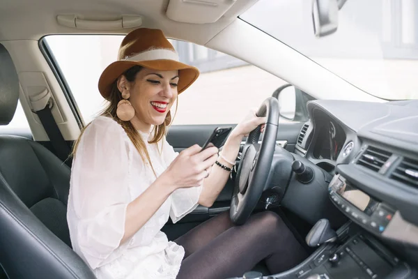 Krásná mladá žena pomocí svého mobilního telefonu v autě — Stock fotografie