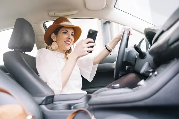 Krásná mladá žena pomocí svého mobilního telefonu v autě — Stock fotografie