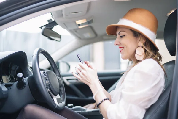 Krásná mladá žena pomocí svého mobilního telefonu v autě — Stock fotografie
