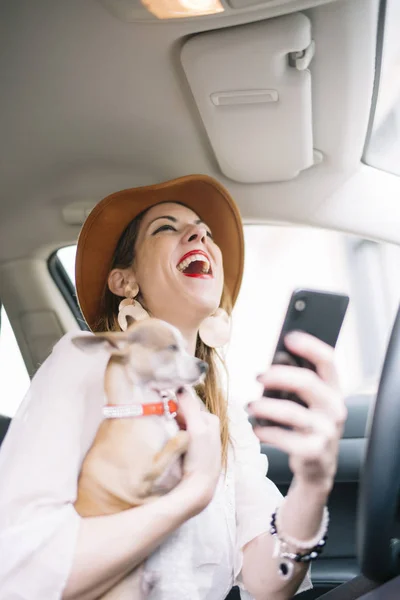 Krásná mladá žena pomocí svého mobilního telefonu v autě s ch — Stock fotografie