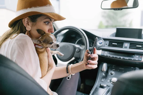 Krásná mladá žena pomocí svého mobilního telefonu v autě s ch — Stock fotografie