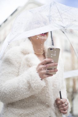 Şemsiye manifatura smartphone cep telefonu ile sarışın kadınla