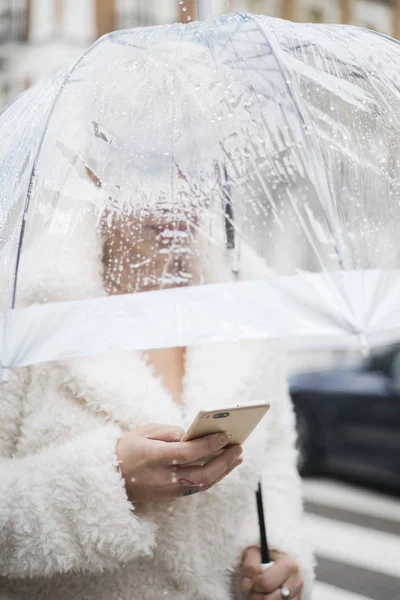 Mulher loira com guarda-chuva mensagens no smartphone — Fotografia de Stock