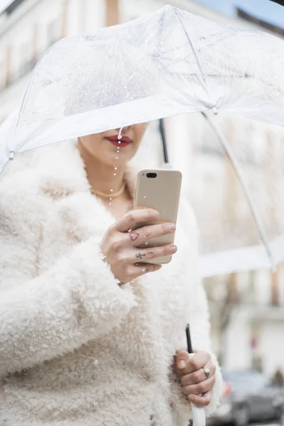 Mulher loira com guarda-chuva mensagens no smartphone — Fotografia de Stock